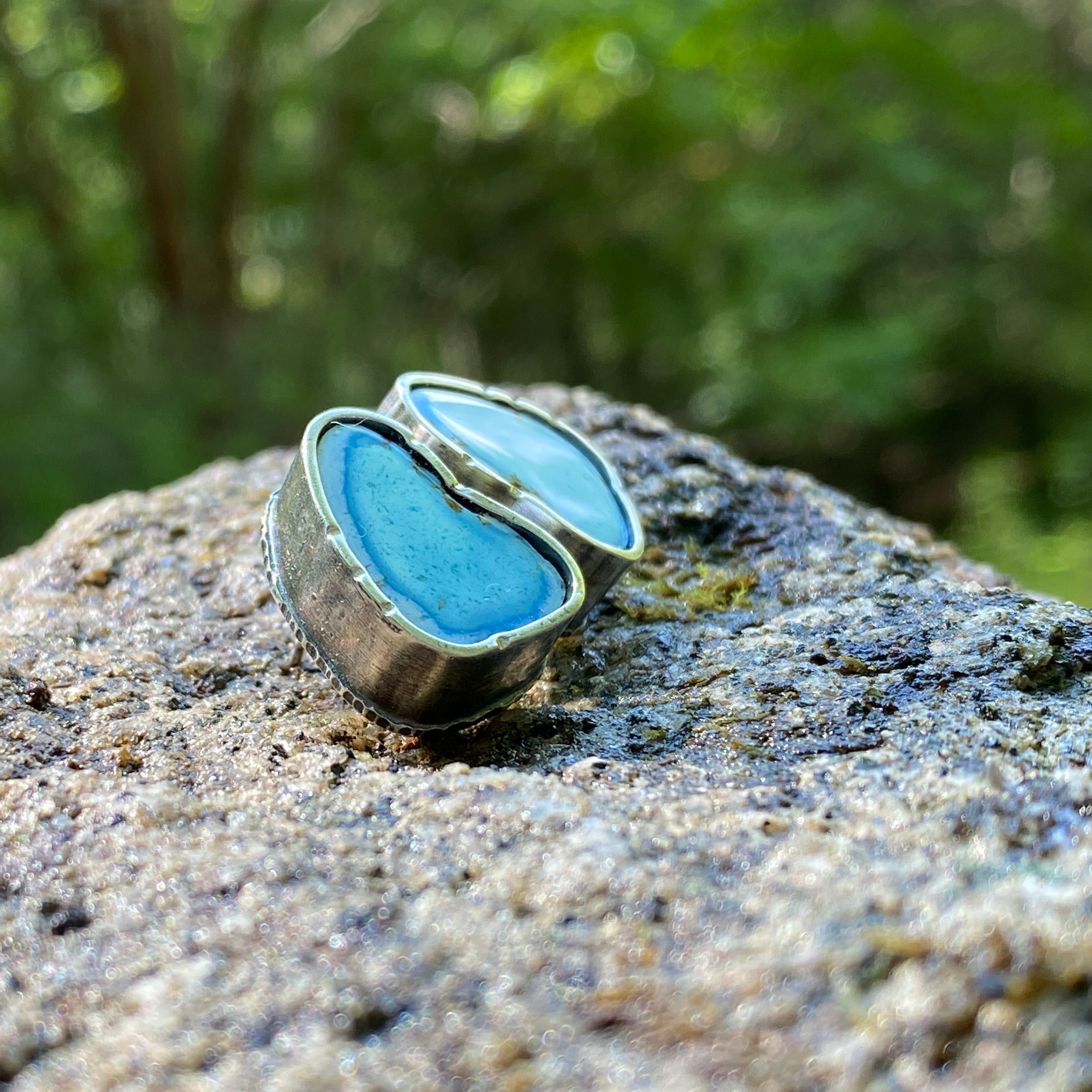 Blue earrings on a rock with a natural background