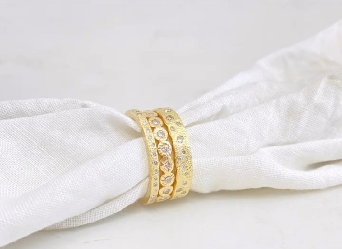 Gold ring with gemstones on a white fabric background