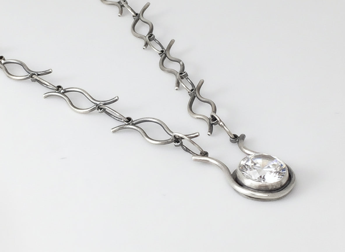 Silver bracelet with a clear gemstone on a white background