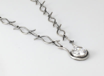 Silver bracelet with a clear gemstone on a white background